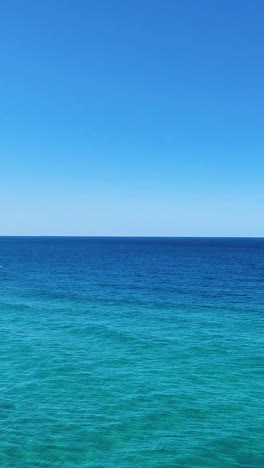 ocean waves and coastline under clear blue sky