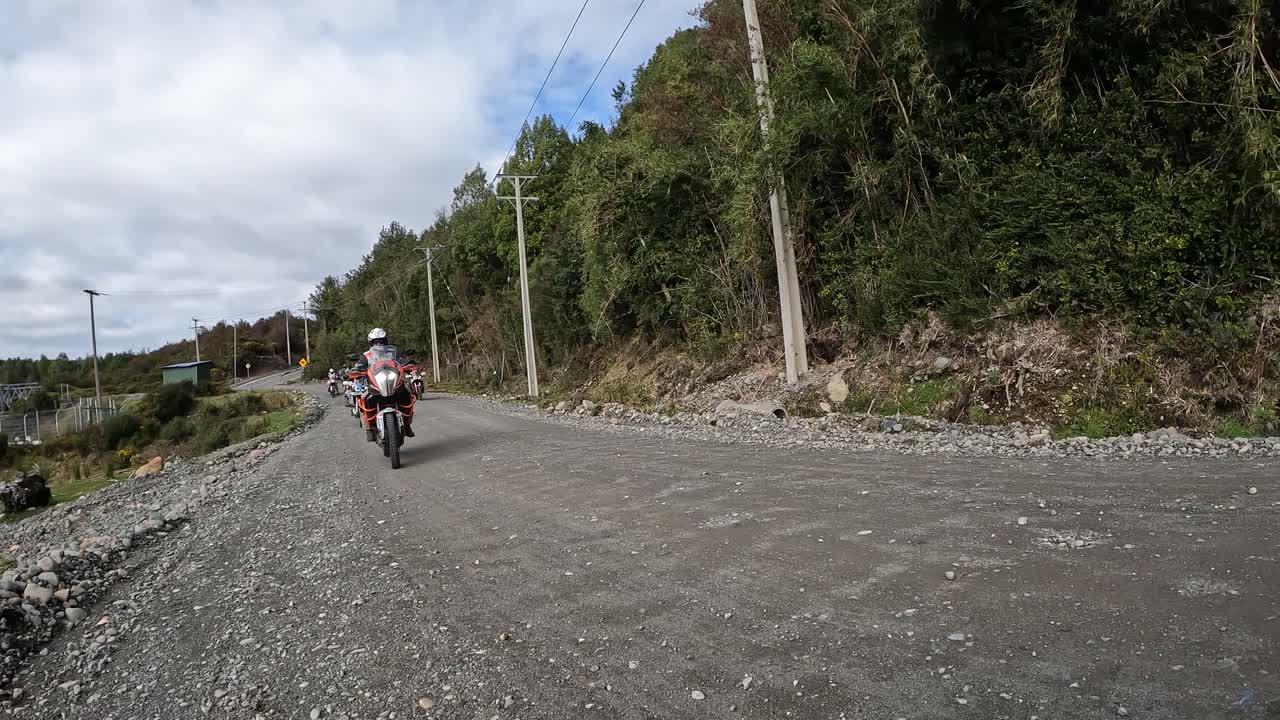 caravan of motorcyclists riding on a rural gravel road. Chilean Patagonia