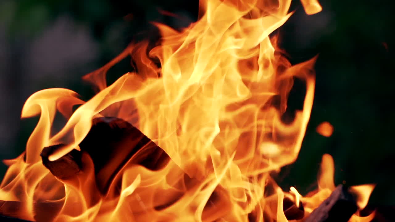 Campfire In The Night. Beautiful fire burns brightly. Embers of the fire climb up. Red flames surging up.