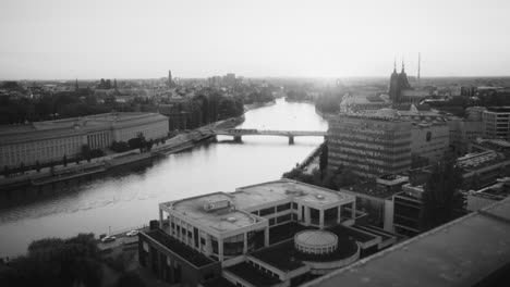 black and white aerial cityscape with river and bridges at sunset