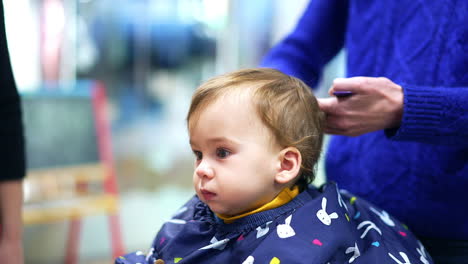 baby getting a haircut at a salon