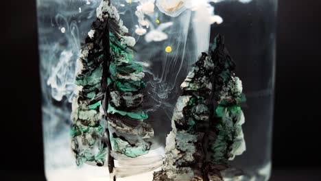 white paint floating in water tank with pine tree drawing inside. stable shot with the sony a7iii.