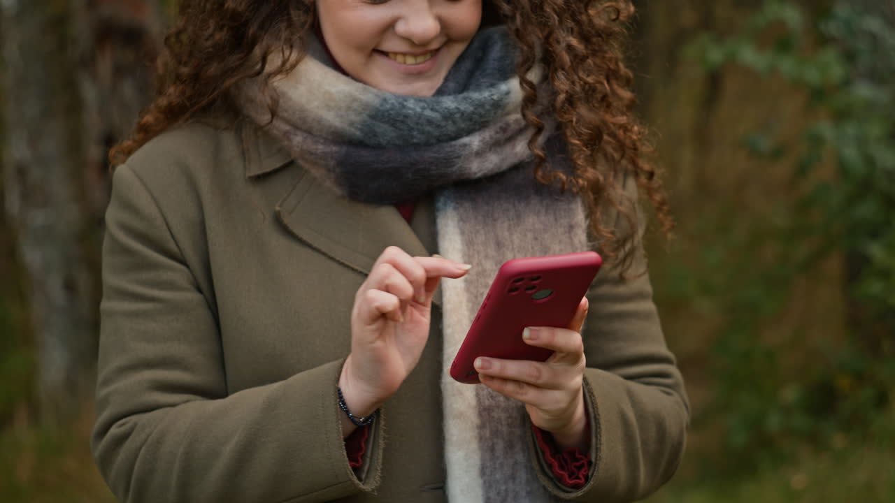 Woman with Curly Hair Using Phone Outdoors