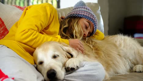 Woman-relaxing-on-sofa-with-her-dog-at-home-4k