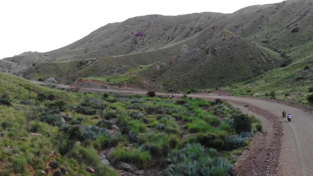 vista aérea de motos conduciendo a lo largo de carreteras remotas a través de valles montañosos en khuzdar