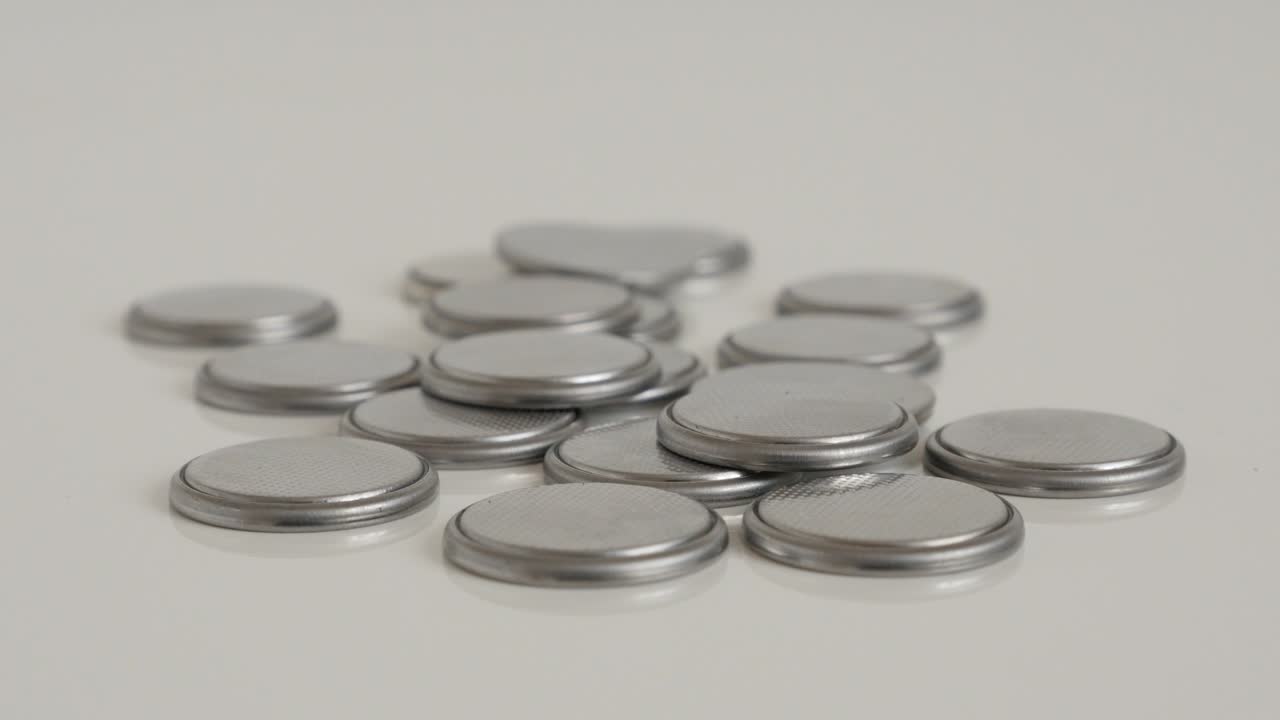 Cell batteries spilled on white 4K tilting video