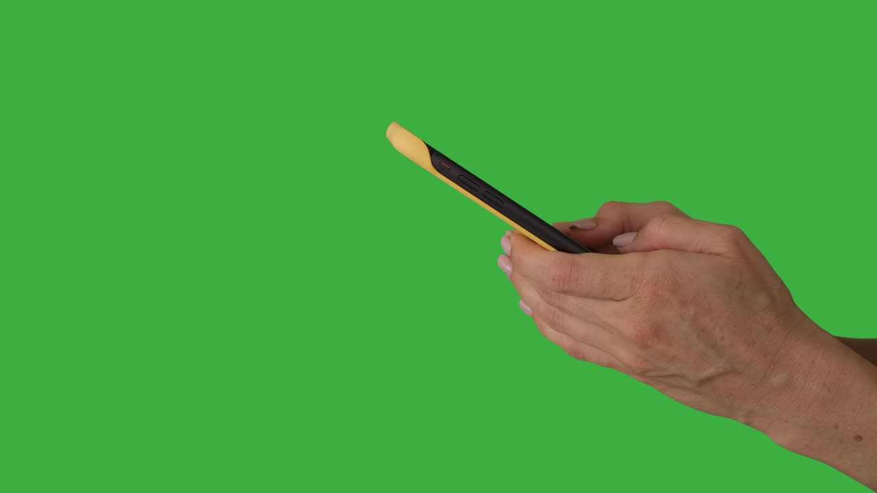Mani che inviano messaggi con un telefono cellulare su sfondo verde