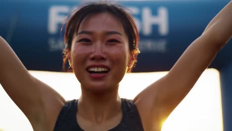 a triumph over adversity: capturing the joy and elation of a runner crossing the finish line with a bright smile at sunset in a race
