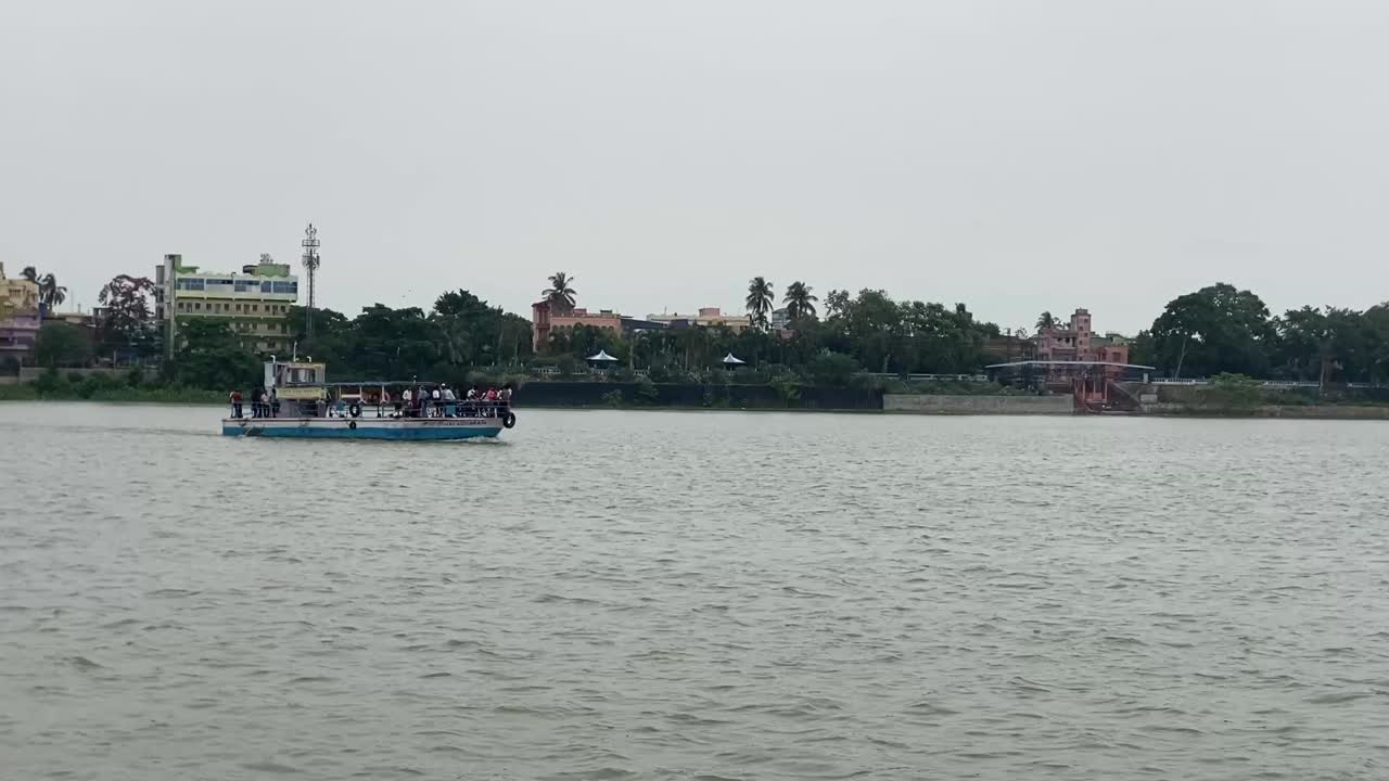 Kolkata, India : Shot of a ferry boat moving over river Ganga on a cloudy day