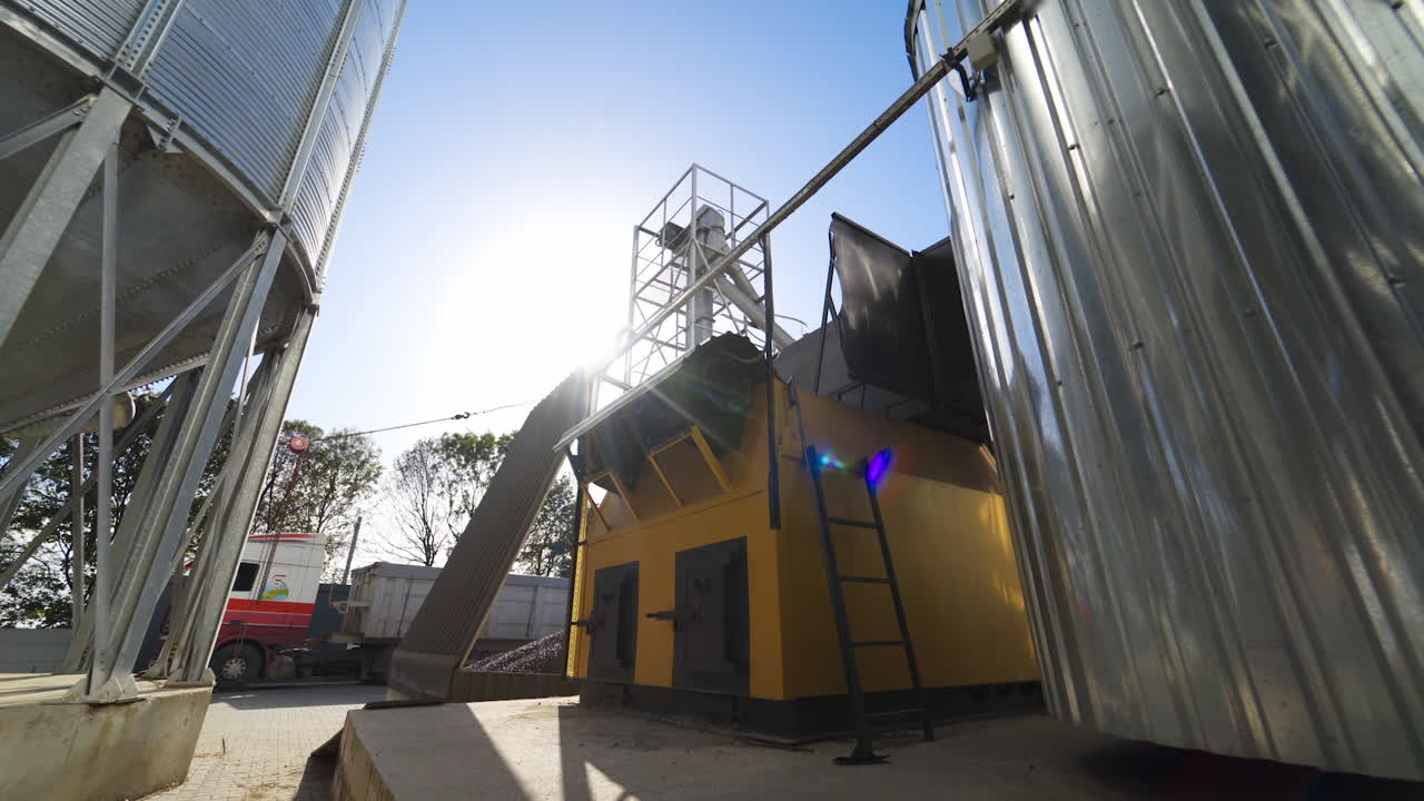 Modern constructions on a factory outdoors. Industrial equipment near grain elevators. Exterior of a modern plant for agribusiness.