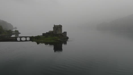 eilean donan castle, a famous scottish castle, is shrouded in fog, creating a mysterious and evocative atmosphere