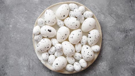 Composition-of-white-traditional-dotted-Pascua-eggs-in-white-ceramic-plate