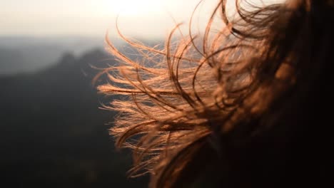 girl's hair flying in the wind in sunrise light close up