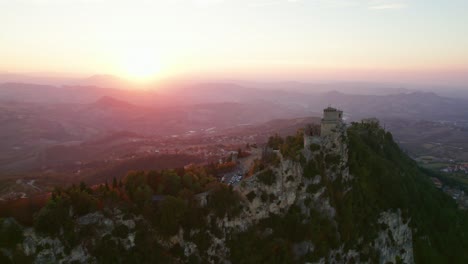 three towers of san marino, italy, drone pull out view during sunset