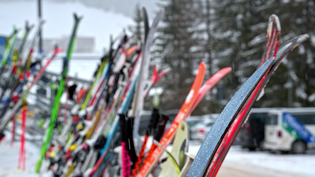Close up of ski bindings and equipment gathered on a stand with the mountains in the background