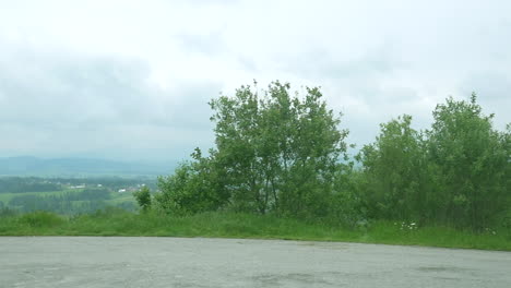 Vista-De-La-Ventana-Del-Lado-Del-Camión-Del-Campo,-Con-Un-Pueblo-En-La-Distancia