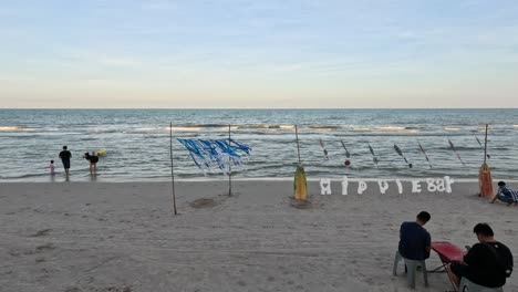 people enjoying the beach as evening approaches