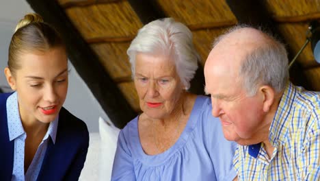 vista frontal de una vieja pareja de ancianos caucásicos interactuando con un agente de bienes raíces en casa 4k