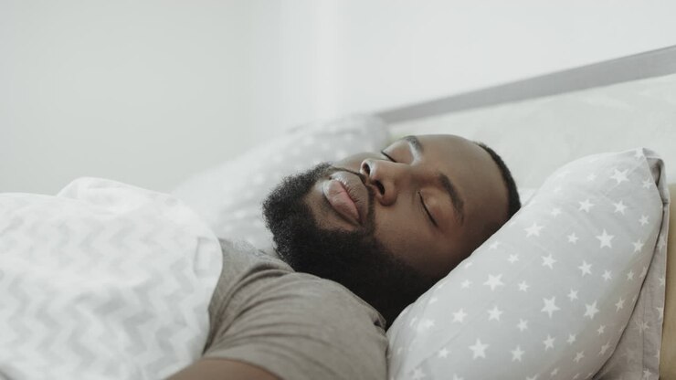 Hombre afroamericano durmiendo en la cama por la mañana.