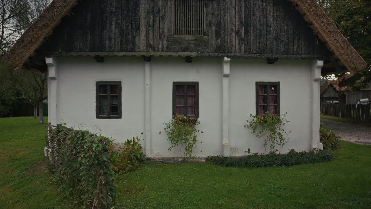 Front of a rustic Croatian house with flowered windows in Kumrovec, Croatia