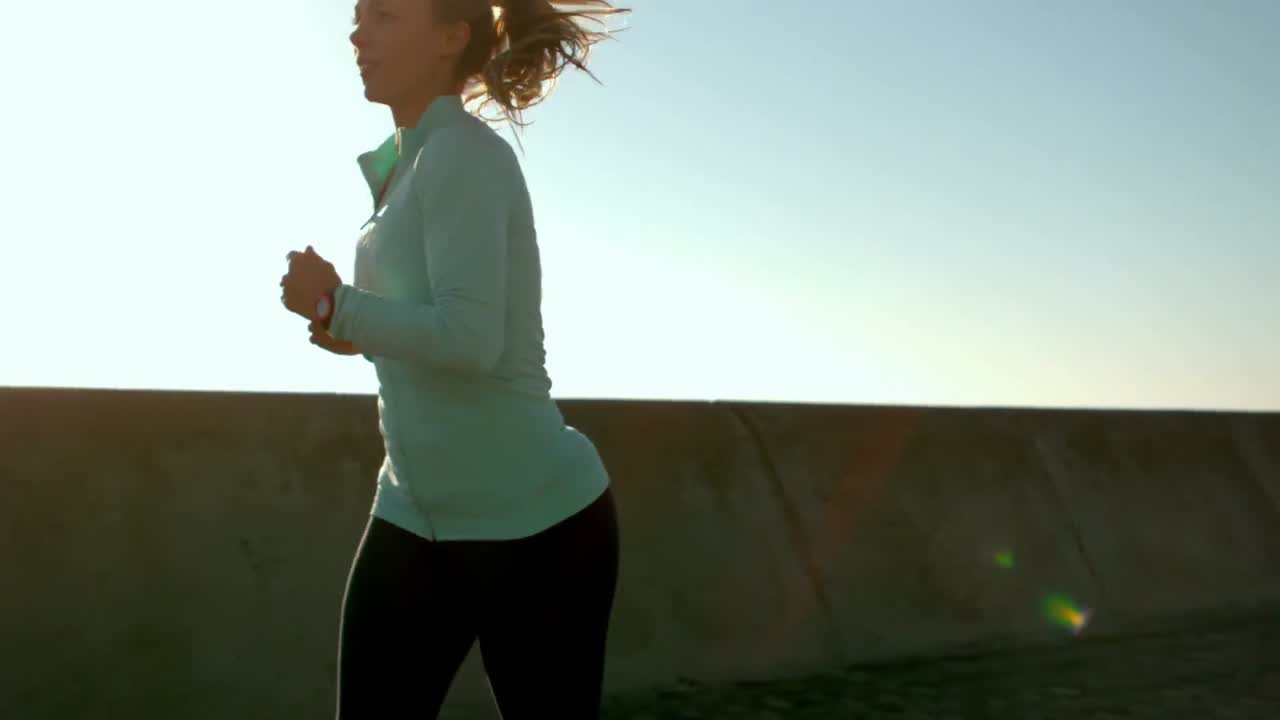 una mujer deportiva sonriente haciendo un trote