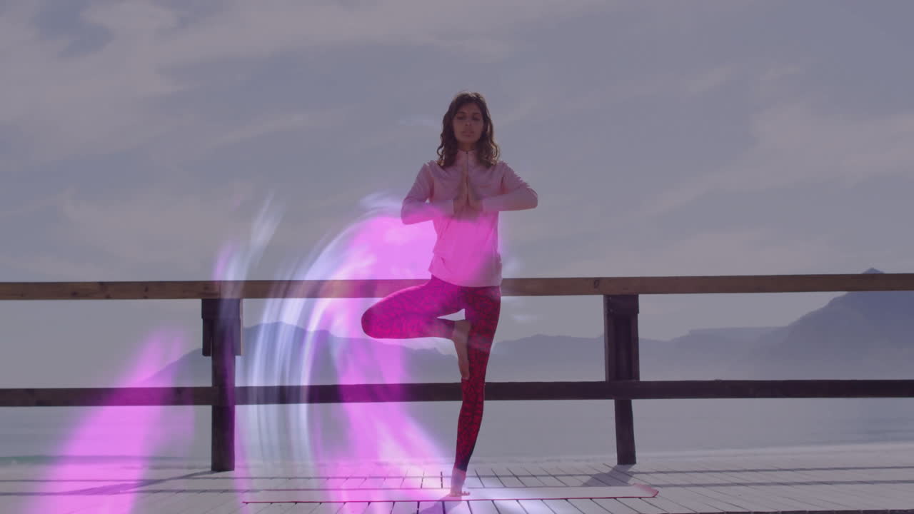 woman practicing yoga tree pose on lakeside deck, showing animated fitness stats overlay