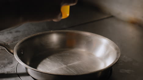 pouring oil into a hot sautee pan