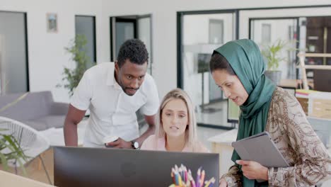 Busy-diverse-business-people-discussing-work-at-desk-with-computer-in-office-in-slow-motion