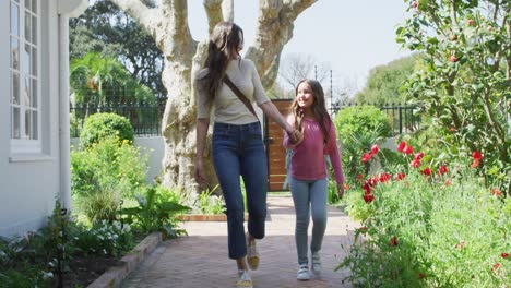 happy caucasian mother and daughter walking outside and having fun