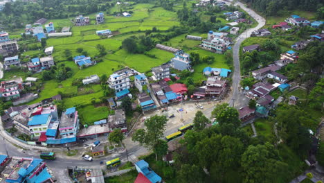 Vista-Aérea-De-Casas-En-Un-Pequeño-Pueblo-Con-Pradera-Verde-En-Nepal.