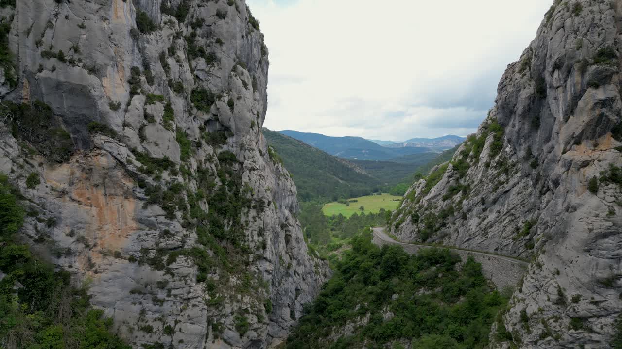 High-quality drone shot of a rugged mountain range surrounded by natural summer beauty.