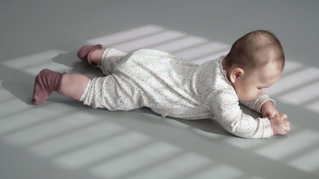 bebé acostado boca arriba con la luz del sol a través de la ventana en la mañana soleada