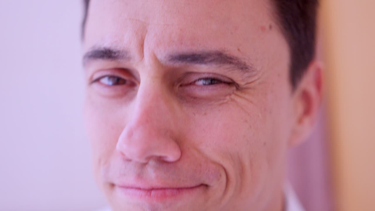 Narcissistic man combing hair and making faces in bathroom mirror