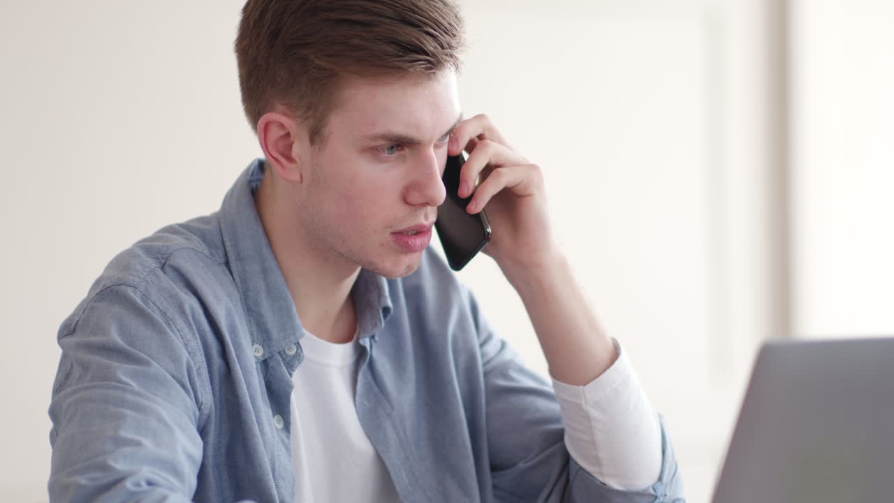 노트북 에서 일 하는 동안 전화 로 이야기 하는 사람