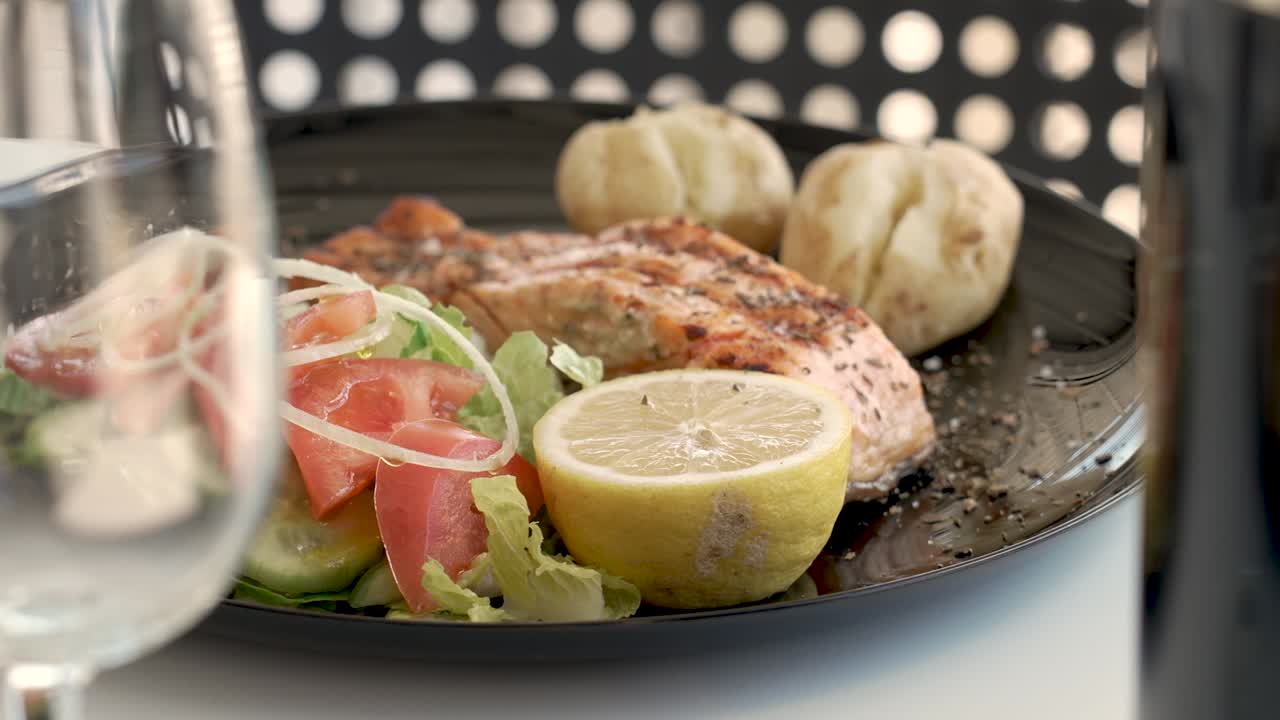 Delightful seafood platter featuring salmon and fresh vegetables at a cozy outdoor dining spot - Close Up Shot