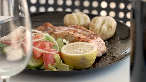 delightful seafood platter featuring salmon and fresh vegetables at a cozy outdoor dining spot - close up shot
