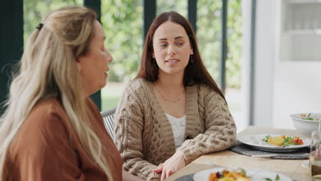 two women having a conversation at a dinner table