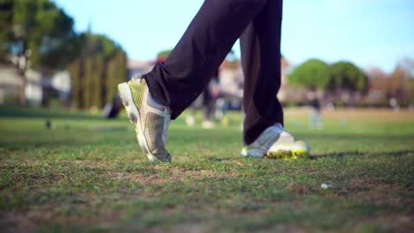 golfista practicando en la calle en un día soleado, vista desde el frente