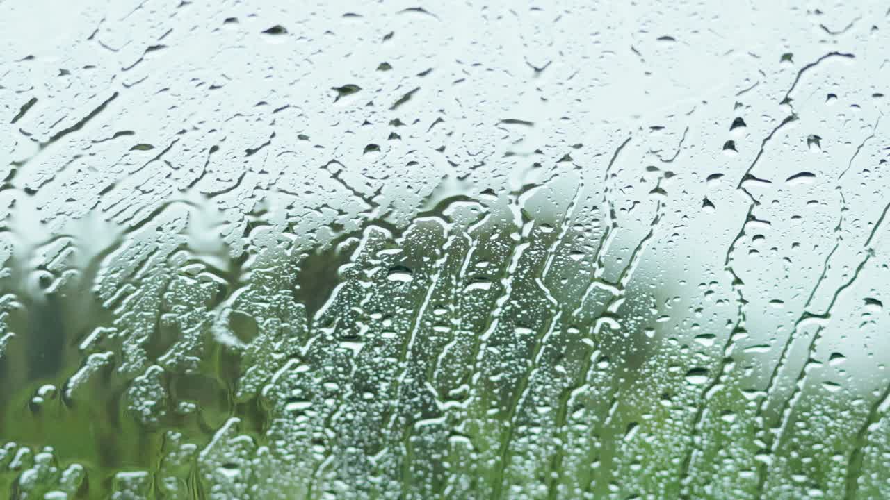 Raindrops on window with blurred background