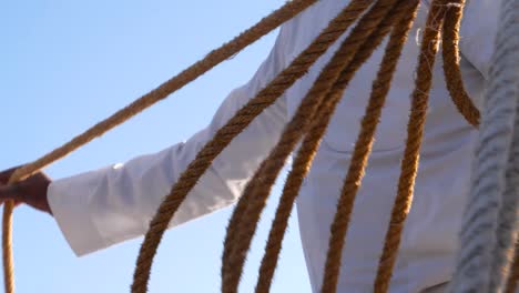 Detail-Eines-Traditionell-Gekleideten-Mannes,-Der-Seile-Für-Eine-Bootsfahrt-In-Assuan,-Ägypten,-Vorbereitet