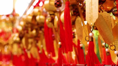 close-up of golden tags adorned with red tassels, capturing vibrant cultural expressions.