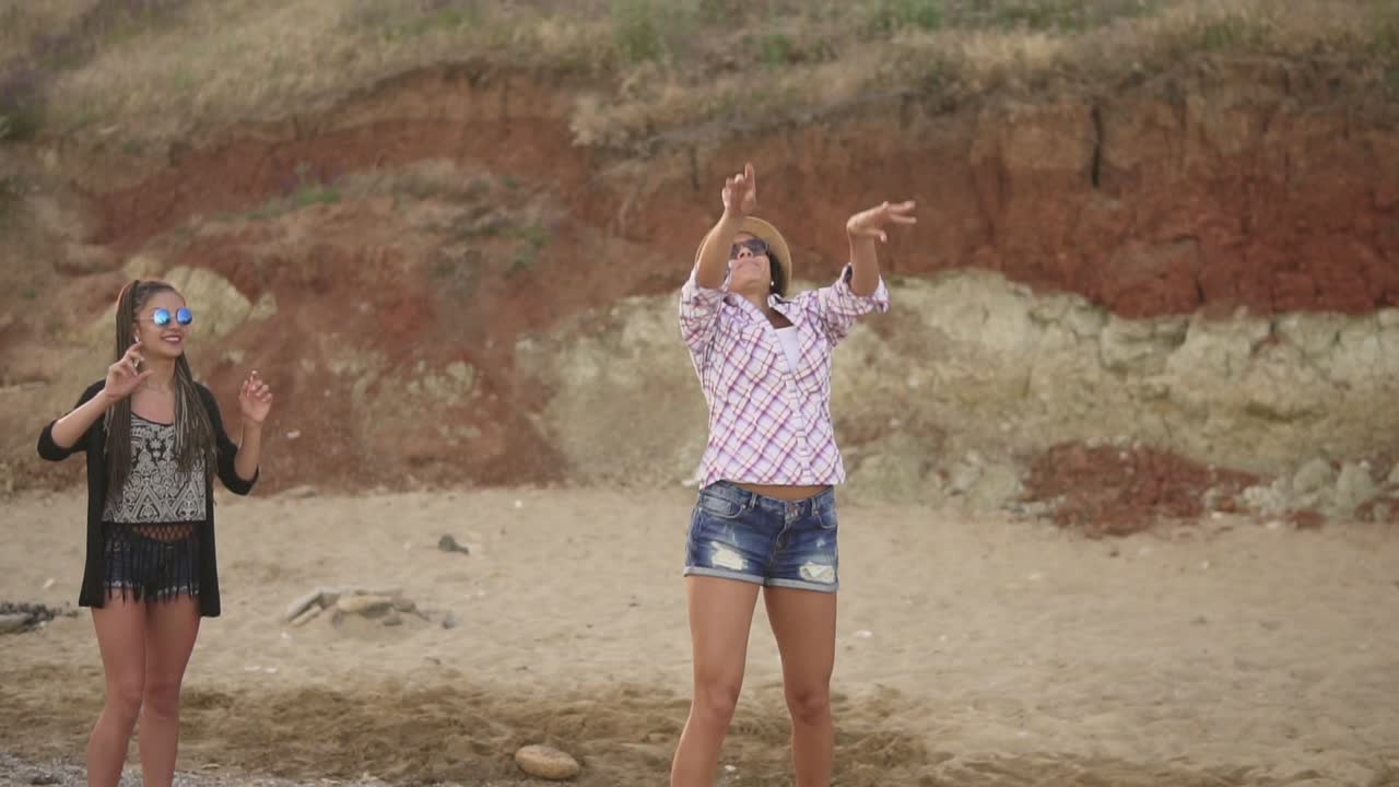 jóvenes amigos alegres jugando al voleibol en la playa junto al mar por la noche. vacaciones activas. disparo en cámara lenta