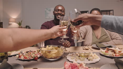 friends celebrating with wine and food at a dinner table