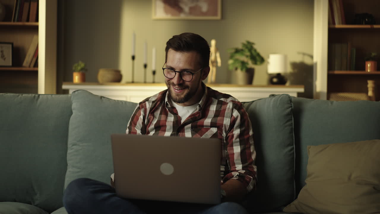 Man using laptop on couch at home