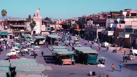 traditional view of crowded market and buildings in the center of marrakesh.