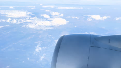 View-of-an-airplane's-wing-soaring-high-above-a-blanket-of-clouds,-symbolizing-travel-and-exploration