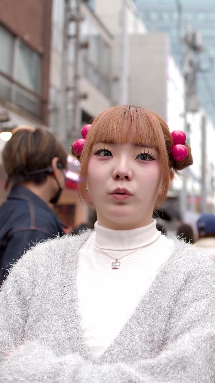 Primo piano di una donna asiatica elegante che parla all'aperto in un affollato quartiere commerciale urbano