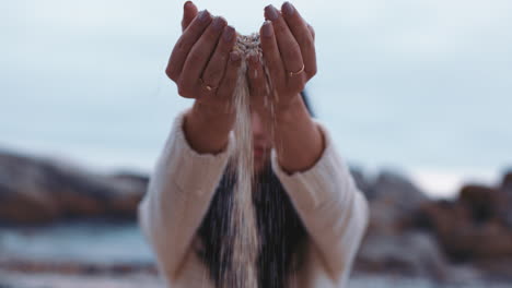 close-up-woman-hands-pouring-sand-running-through-fingers-on-beach