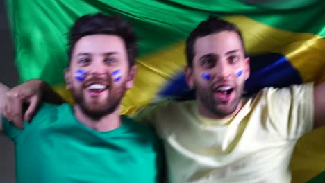 brazilian friends celebrating with brazil flag