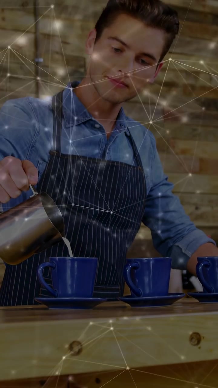 Video verticale: Barista che prende una brocca, versa il latte in tazze blu, prepara il caffè con una sovrapposizione.